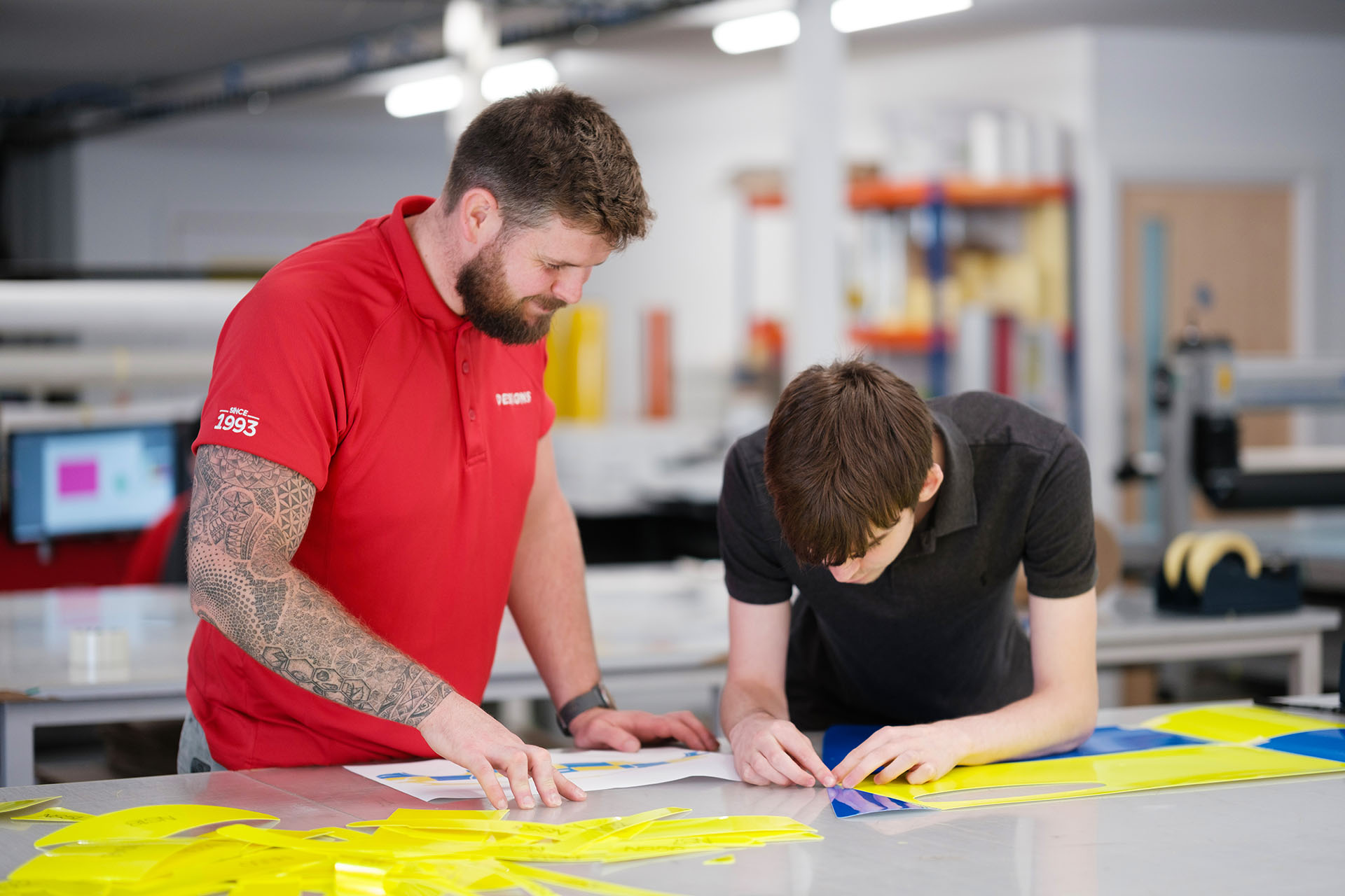 Two Designs employees working on emergency services van graphics.